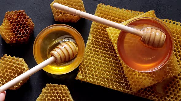 Honey dripping, pouring from a wooden spoon. Liquid fresh golden honey. Honeycombs. Healthy organic