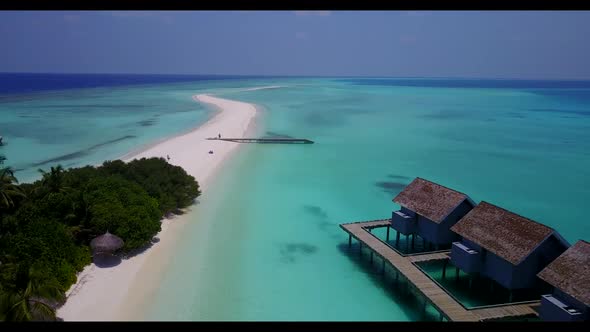 Aerial flying over seascape of tropical seashore beach holiday by aqua blue ocean and clean sandy ba