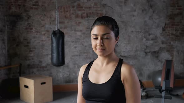 Pretty female professional posing camera after fitness training