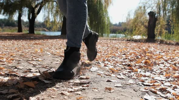 Female Legs Walking on Fallen Autumn Leaves in the Park in Slow Motion