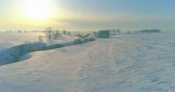 Aerial View of Cold Winter Landscape Arctic Field Trees Covered with Frost Snow Ice River and Sun