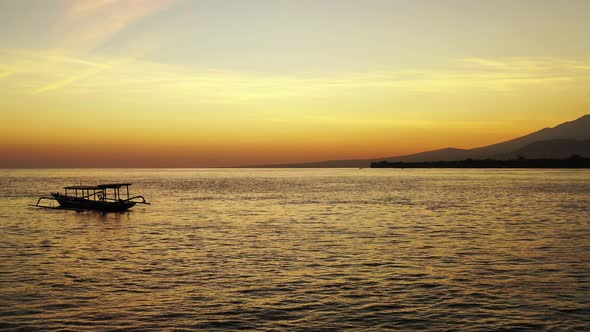 Silhouette of Indonesian fishing boat Jukung, floating on calm lagoon near tropical island, reflecti