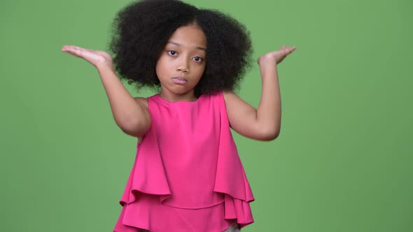 Young Cute African Girl with Afro Hair Shrugging Shoulders