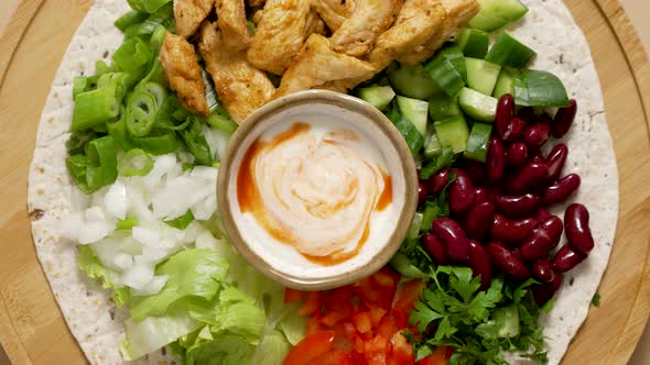 Fresh Ingredients for Preparing Tortilla with Vegetables Grilled Chicken and Sauce