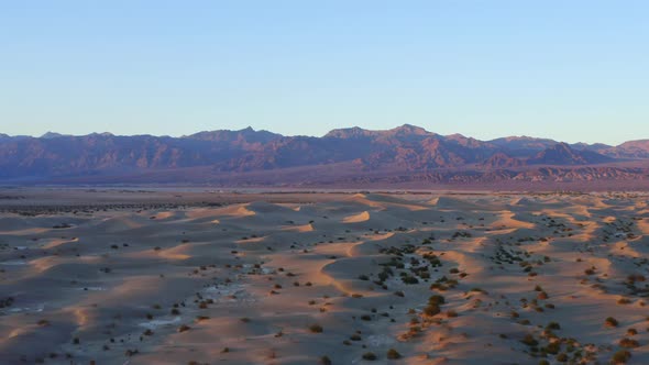 Wavy sand dunes with mountains in the background. Death Valley landscape. Aerial