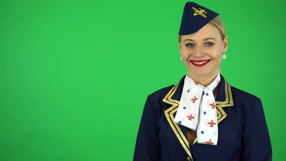 A Young Beautiful Stewardess Smiles at the Camera - Green Screen Studio