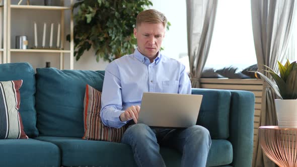 Middle Aged Man Sad for Failure Working on Laptop