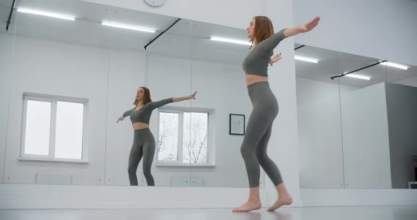 Dancer Woman Jumps in Slow Motion Infront of Mirror Wall Gymnastics in the White Dance Hall