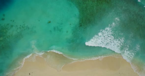 Beautiful drone travel shot of a white paradise beach and aqua turquoise water background in 4K