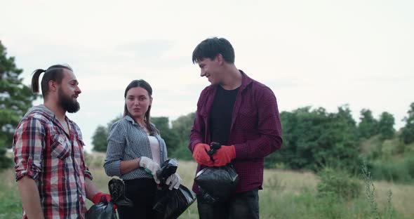 Team of Volunteers with Garbage Bags Talk Show Thumbs and Smile on Nature