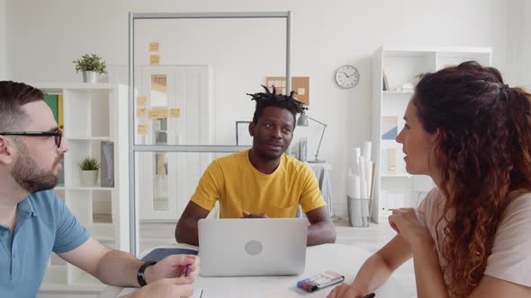 Three Multiethnic Colleagues Having Discussion in Office