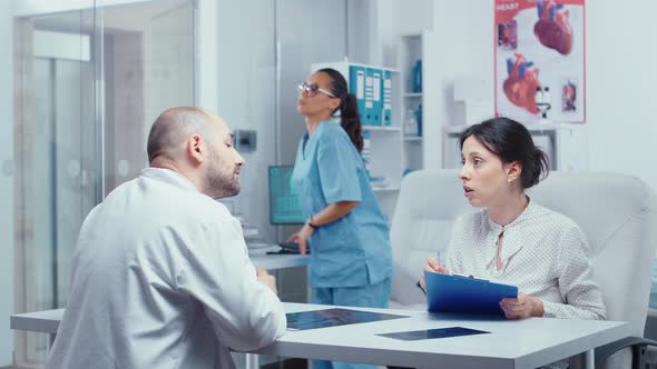 Woman Filling Out Forms at Doctor Office