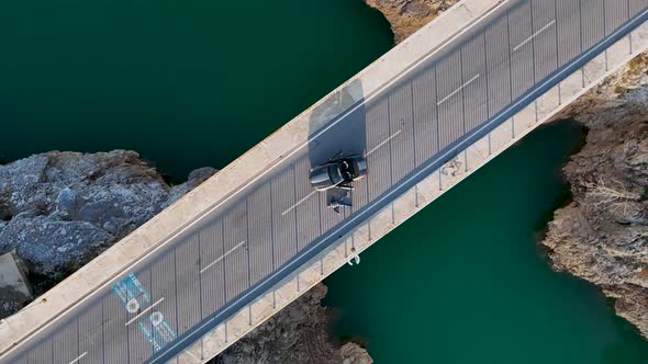 A car passes through a bridge over a river aerial view 4 K