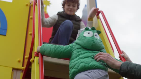 Urban Family Playing on Slide Together