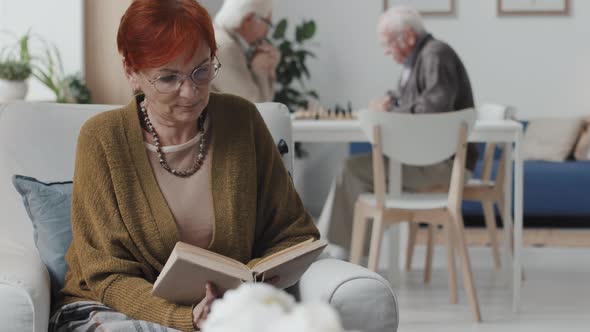 Senior Woman Reading Book in Nursing Home