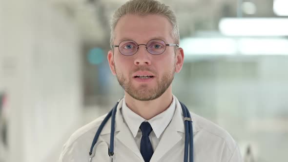 Portrait of Friendly Young Male Doctor Talking on Video Call