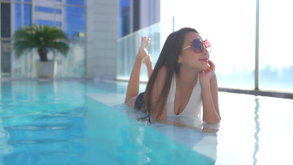 Young asian woman enjoy around outdoor swimming pool for leisure