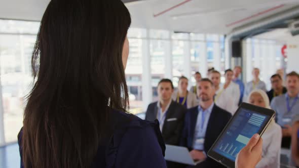 Female speaker addressing the audience at a business seminar