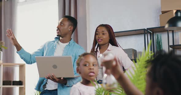 African American Couple with Kids Standing in their Newly Acquired Apartment and Planning