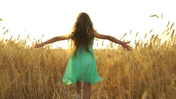 Young Girl In The Dress Is Running Across The Field