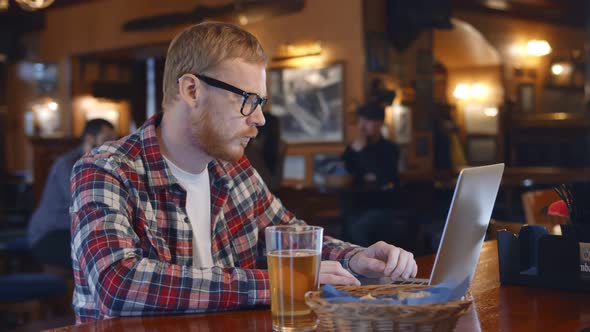 Handsome Young Business Man or Remote Working with Laptop in Bar