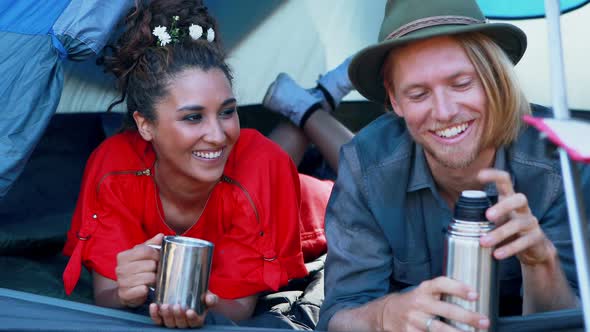 Couple sharing coffee in tent