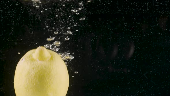 Close up of a lemon falling into water