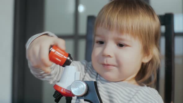 Toddler Boy of 23 Years Old Playing with a Toy Microscope
