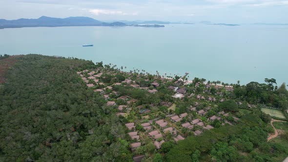 secluded resort on coconut island in thailand with empty beaches and blue water, aerial