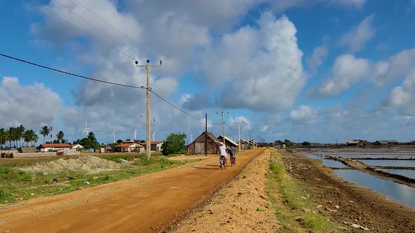 Two Indians On Bicycle Travel On Village Road