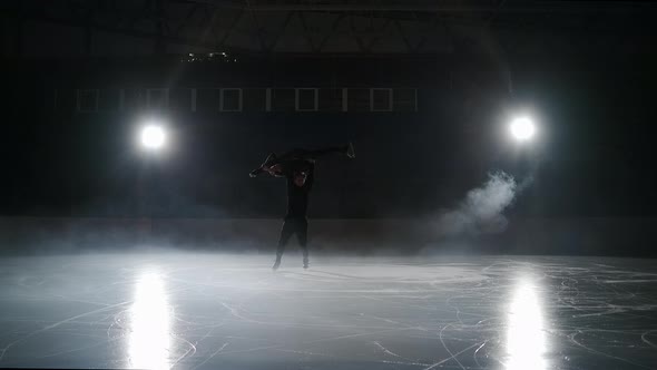 Pair of Figure Skaters are Performing High Lift and Spinning on Ice Rink at Darkness Slow Motion