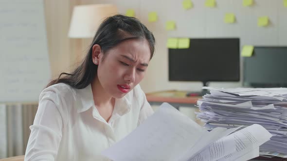 Close Up Of Tired Asian Woman Shaking Her Head While Working Hard With Documents At The Office