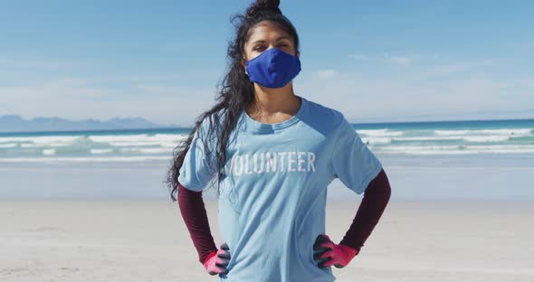 Portrait of mixed race woman wearing volunteer t shirt and face mask looking at camera