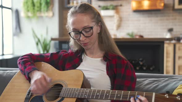 Woman is Playing Guitar at Home