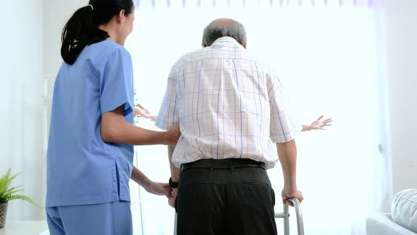 Asian young nurse take care a senior with a walker.