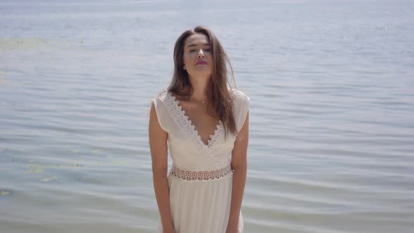 Portrait Beautiful Young Girl with Long Brunette Hair Wearing a Long White Summer Fashion Dress