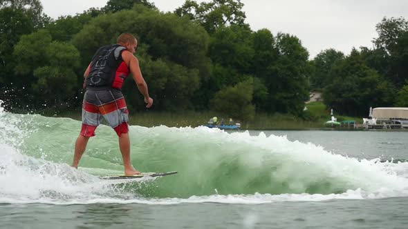 A man wake surfing behind a boat on a lake