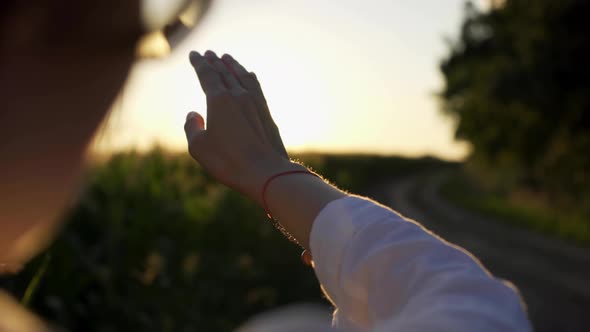 Woman's Hand Against The Sunset Sun, The Girl's Hand Touches The Sun, The Sun's Rays Through Her