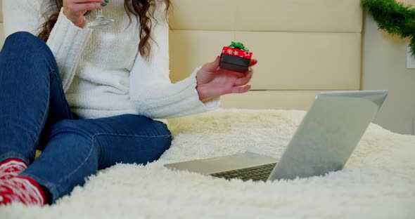 Close Up Gift. Holidays Christmas Interior Winter Concept. Young Woman in Cozy Bedroom with Laptop