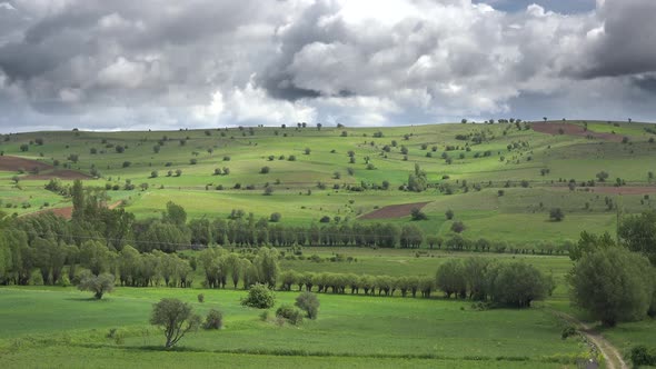 Small Fields With Trees and Low Green Hills in Moorland