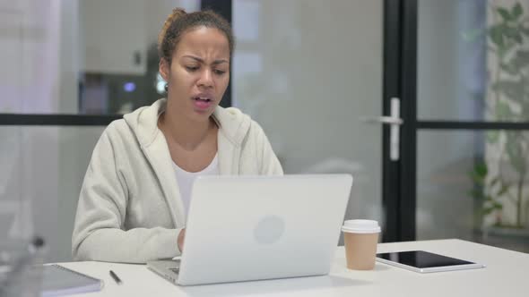 African Woman Reacting to Loss While Using Laptop