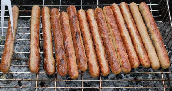 Grilled sausages roasting on barbecue grill, outdoors