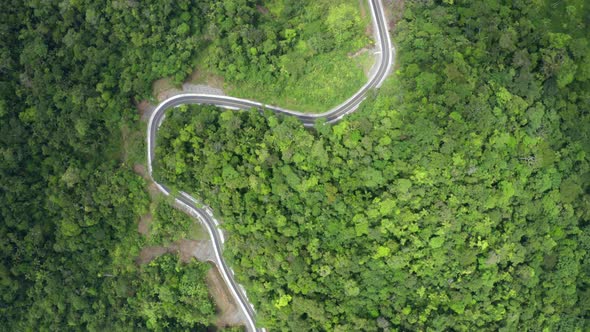A closed curve in the road winding through the hills of the Andes in Ecuador