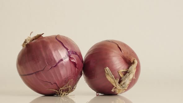 Pair of onions with red skin and white flesh slow tilt 4K 2160p 30fps UltraHD footage - Organic Alli