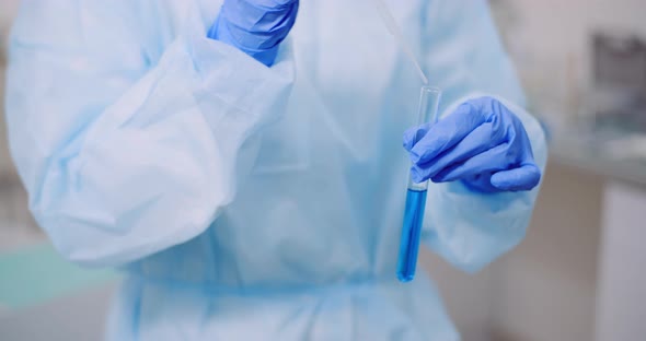 Portrait of Female Scientist Analyzing with a Pipette at Laboratory
