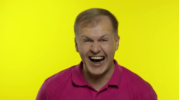 Portrait of Young Man Posing in Pink T-shirt. Happy Handsome Guy Laughing Loud, Looking To Camera