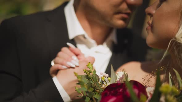 Couple of Lady with Bouquet and Man Holds Hands in Park