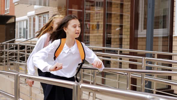 Two Sisters of Different Ages Run to School Being Late for Classes