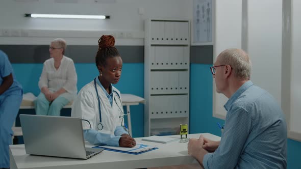 Doctor Giving Prescription Document with Stamp to Old Patient alt