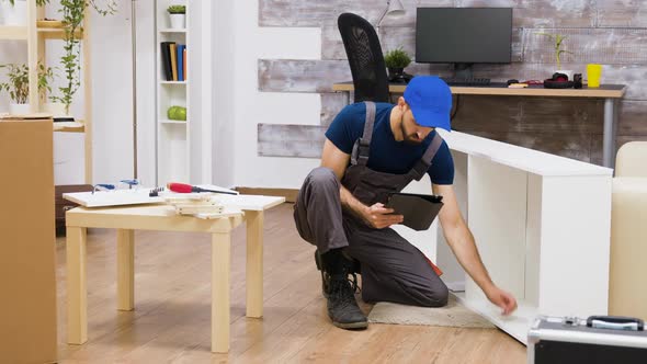 Male Worker Using Modern Technology for Furniture Assembly